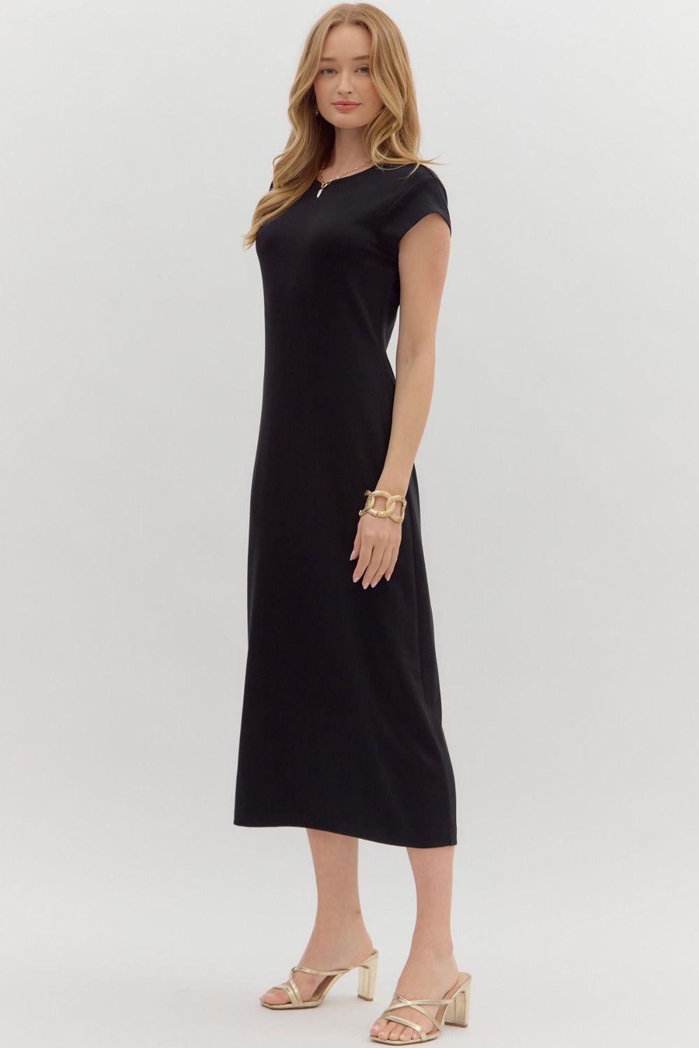 Side view of black cap-sleeve midi dress showing straight silhouette
