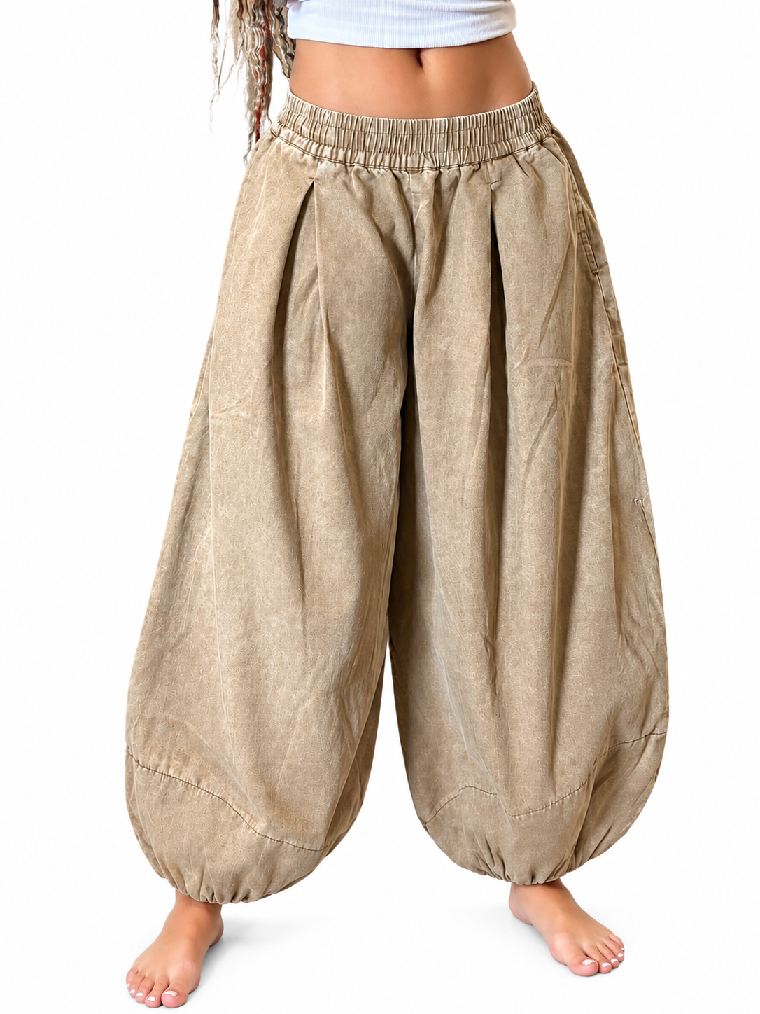 Front view of mocha pleated balloon pants with an elastic waistband and gathered ankles on a model.