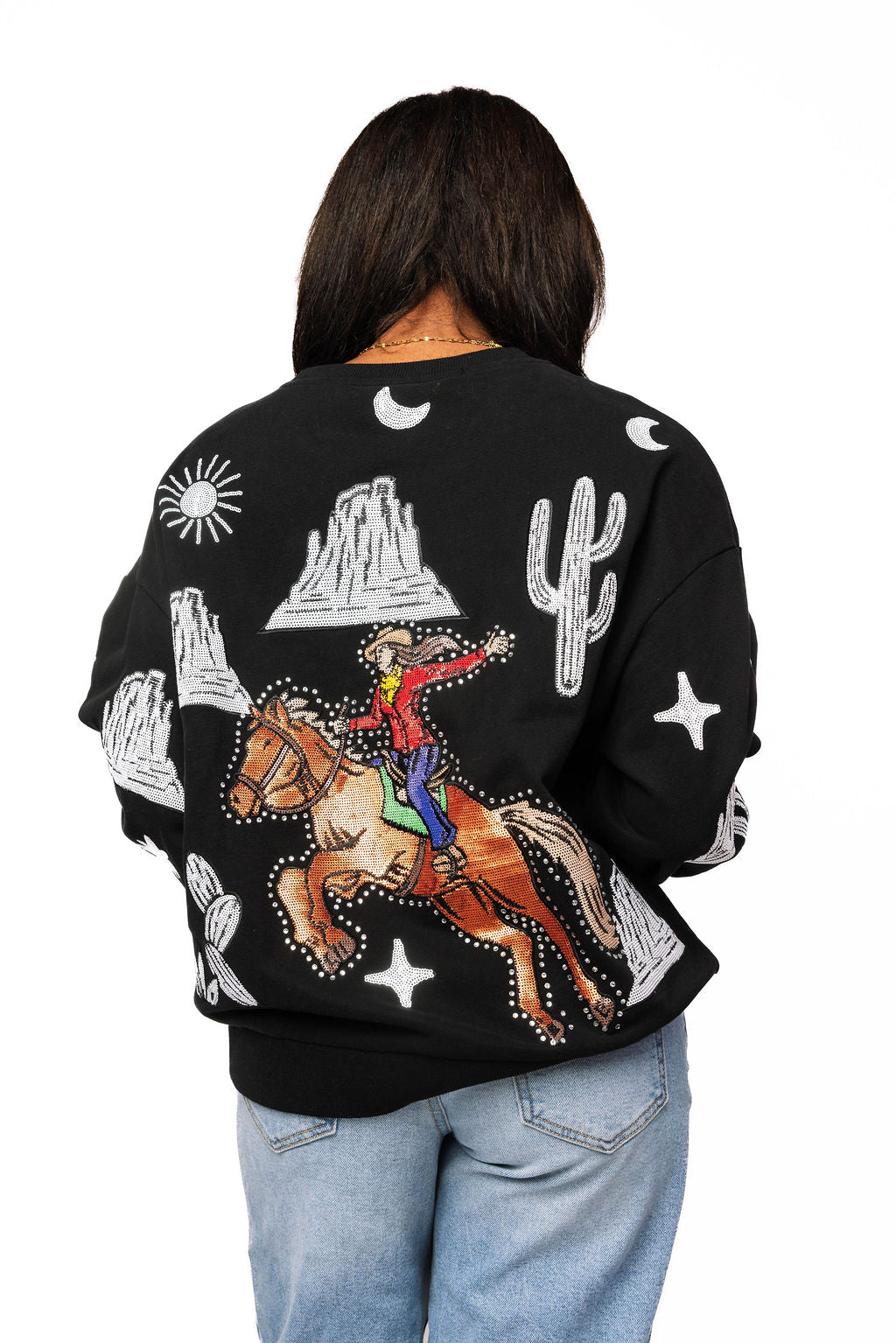 Back view of the black Queen of Sparkles sweatshirt showing a colorful bucking cowgirl on horseback with white western motifs.