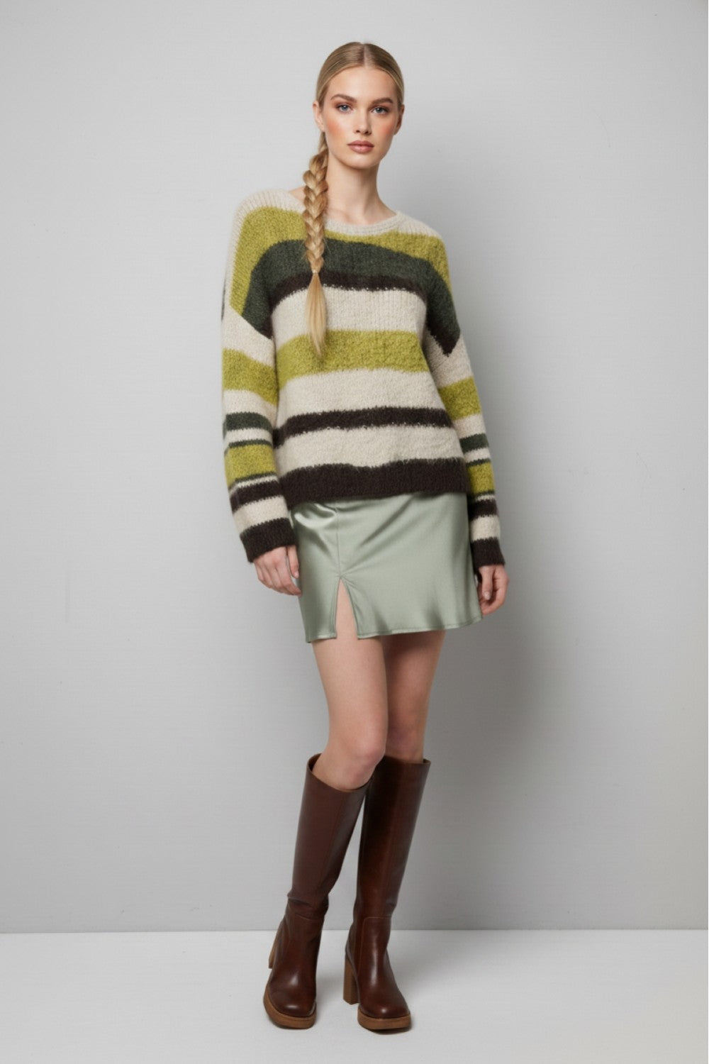 Full-length front outfit view of the olive and cream striped fuzzy sweater with a sage skirt and brown boots