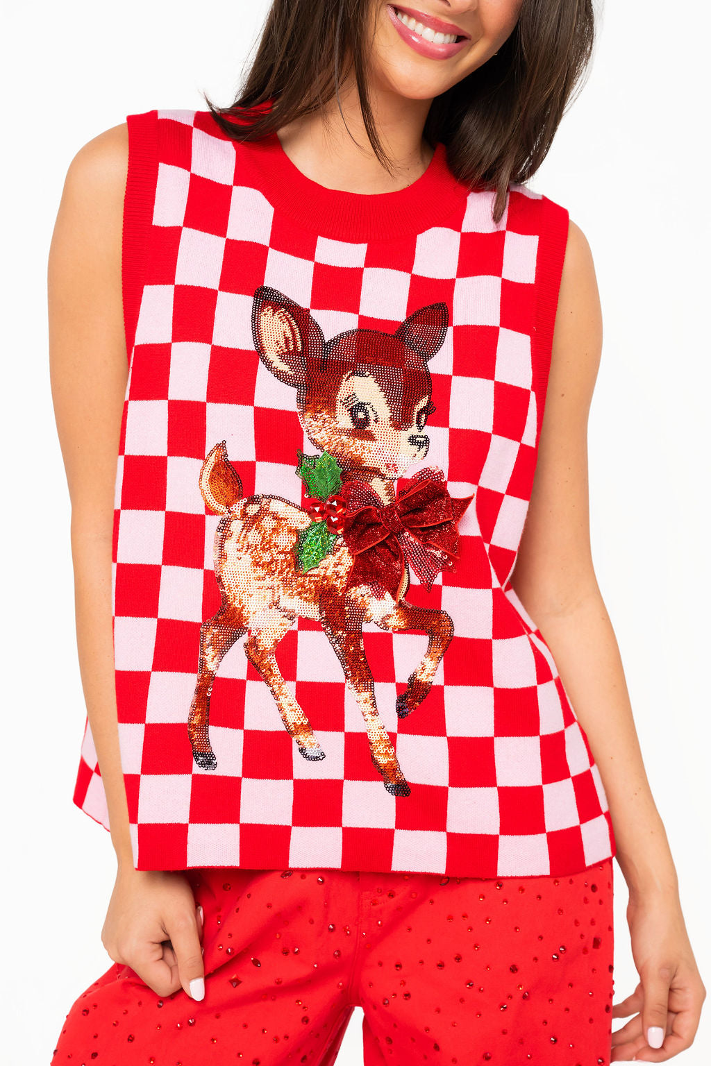 Front view of red and pink checkered sleeveless knit vest with sequined reindeer and red bow motif.