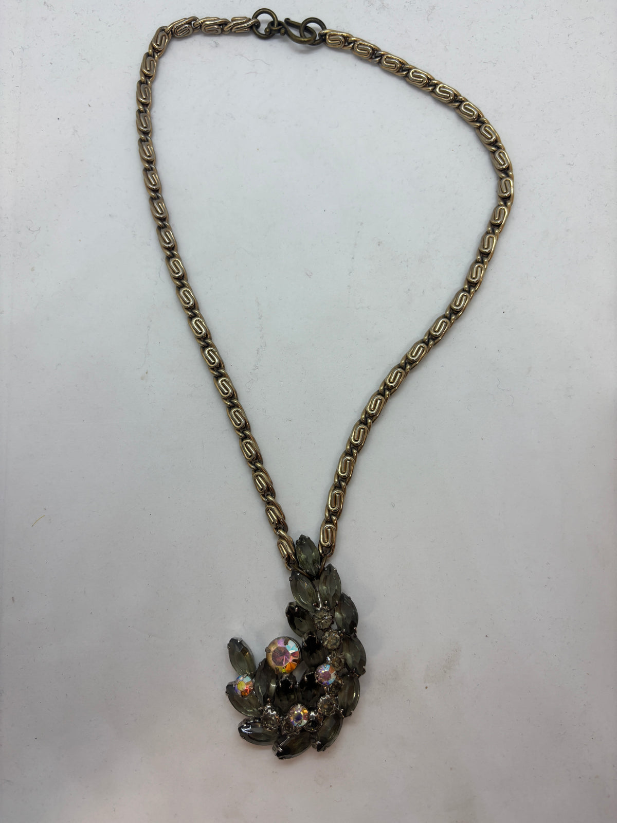 Grey brooch on gold-tone chain necklace