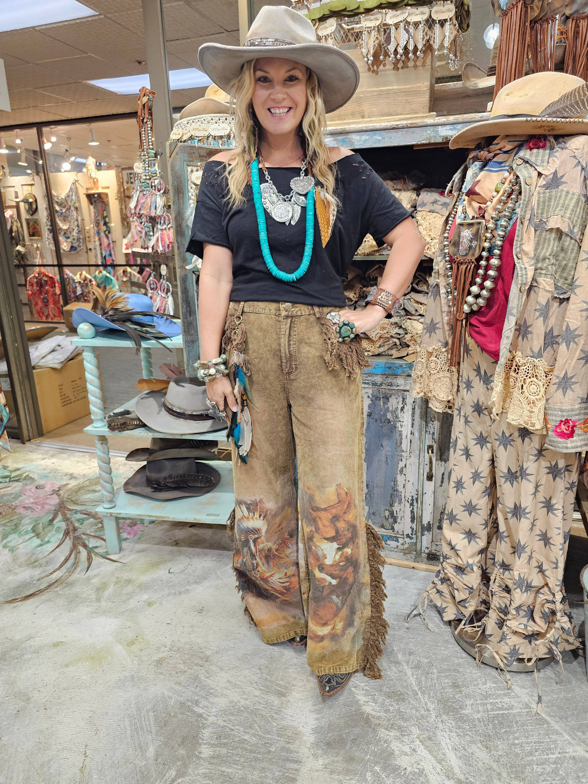 Woman wearing tan Warrior corduroy jeans with wide legs and artwork in boutique setting
