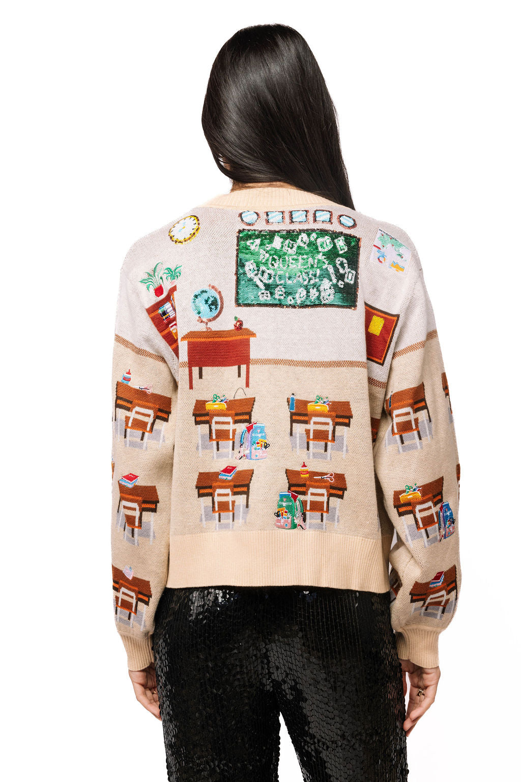 Back view of the beige Queen of Sparkles cardigan showing its multicolor classroom and school-themed panels.