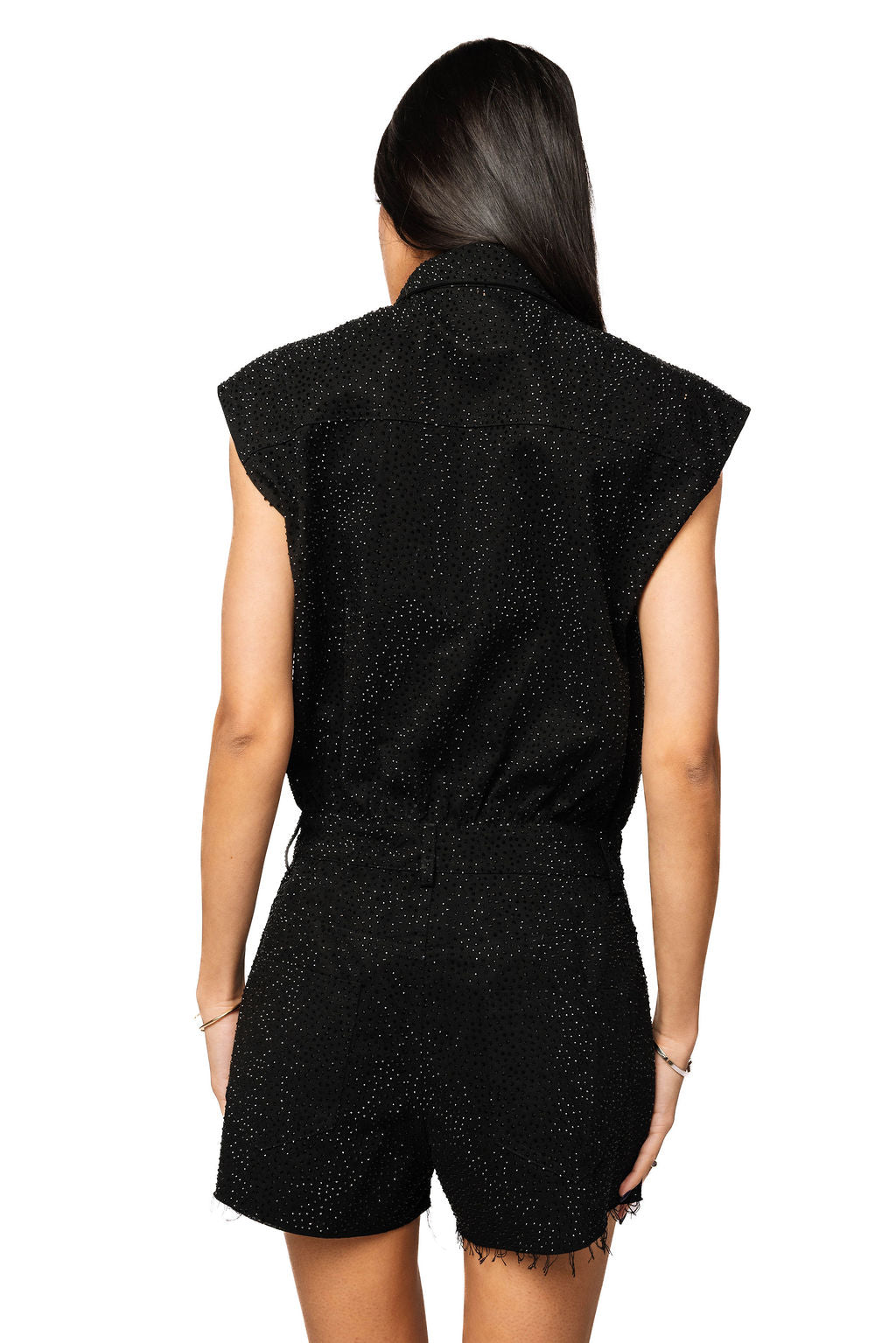Back view of the black Queen of Sparkles rhinestone romper on a model, showing its glittering sleeveless back and shorts.