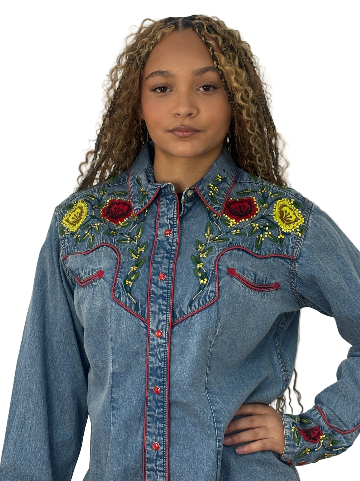 Front view of a model wearing the Rockmount denim Western shirt with red and yellow rose details and rhinestone accents