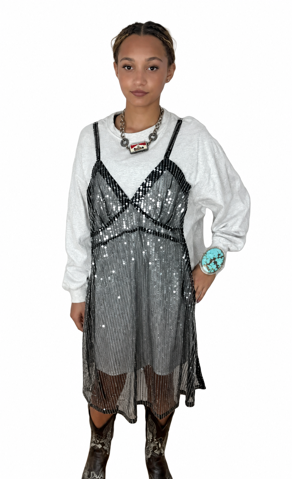 Front view of a long-sleeve white dress layered under a black sequin slip overlay on a model.