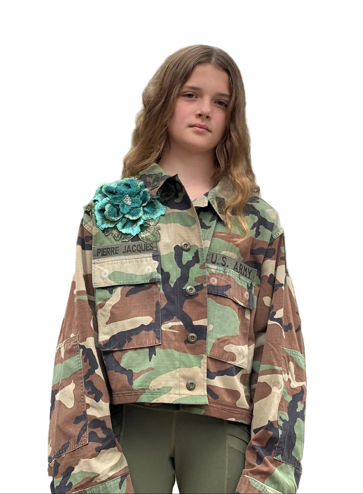 Front view of camouflage button jacket with a raised teal fabric flower at the shoulder and chest pockets