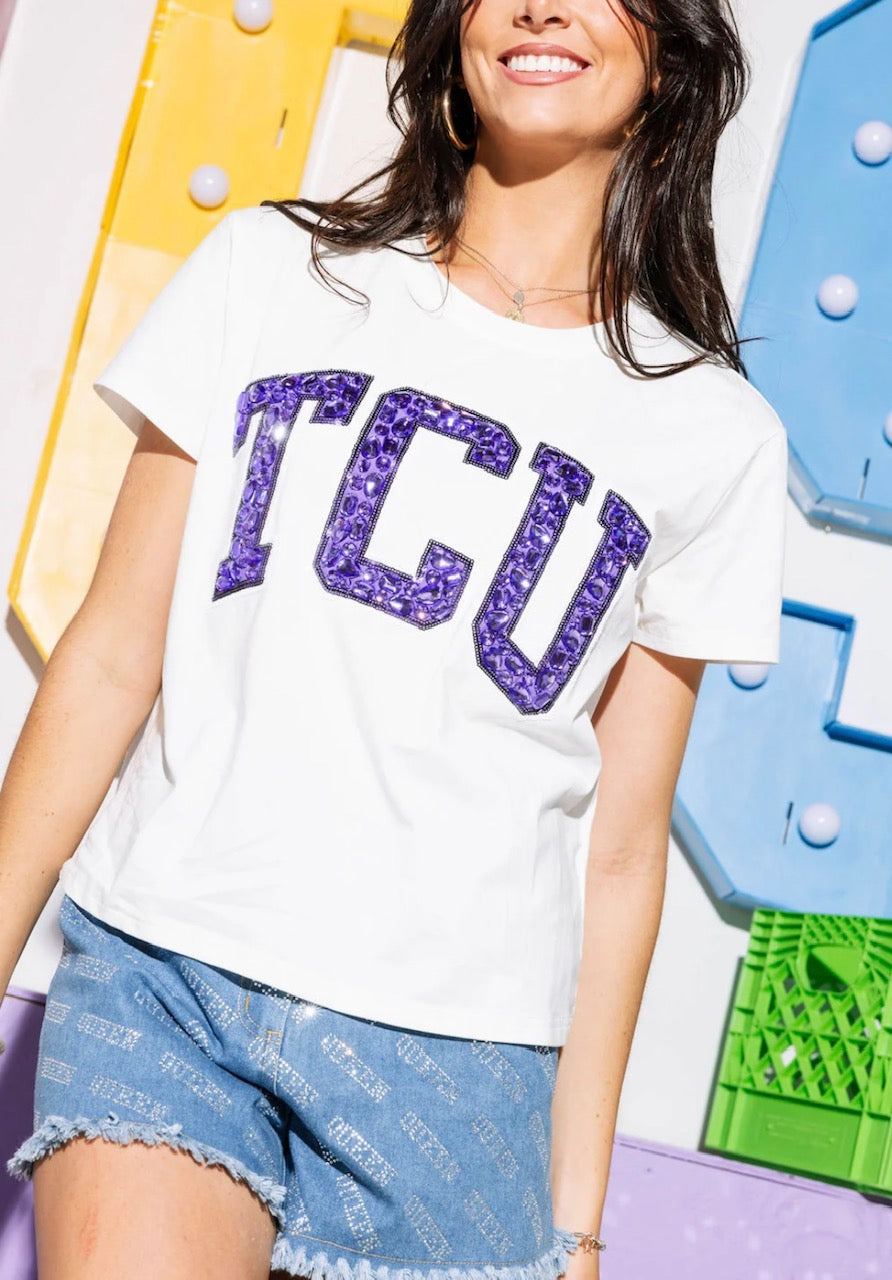 Close view of purple jeweled TCU letters on white short-sleeve tee