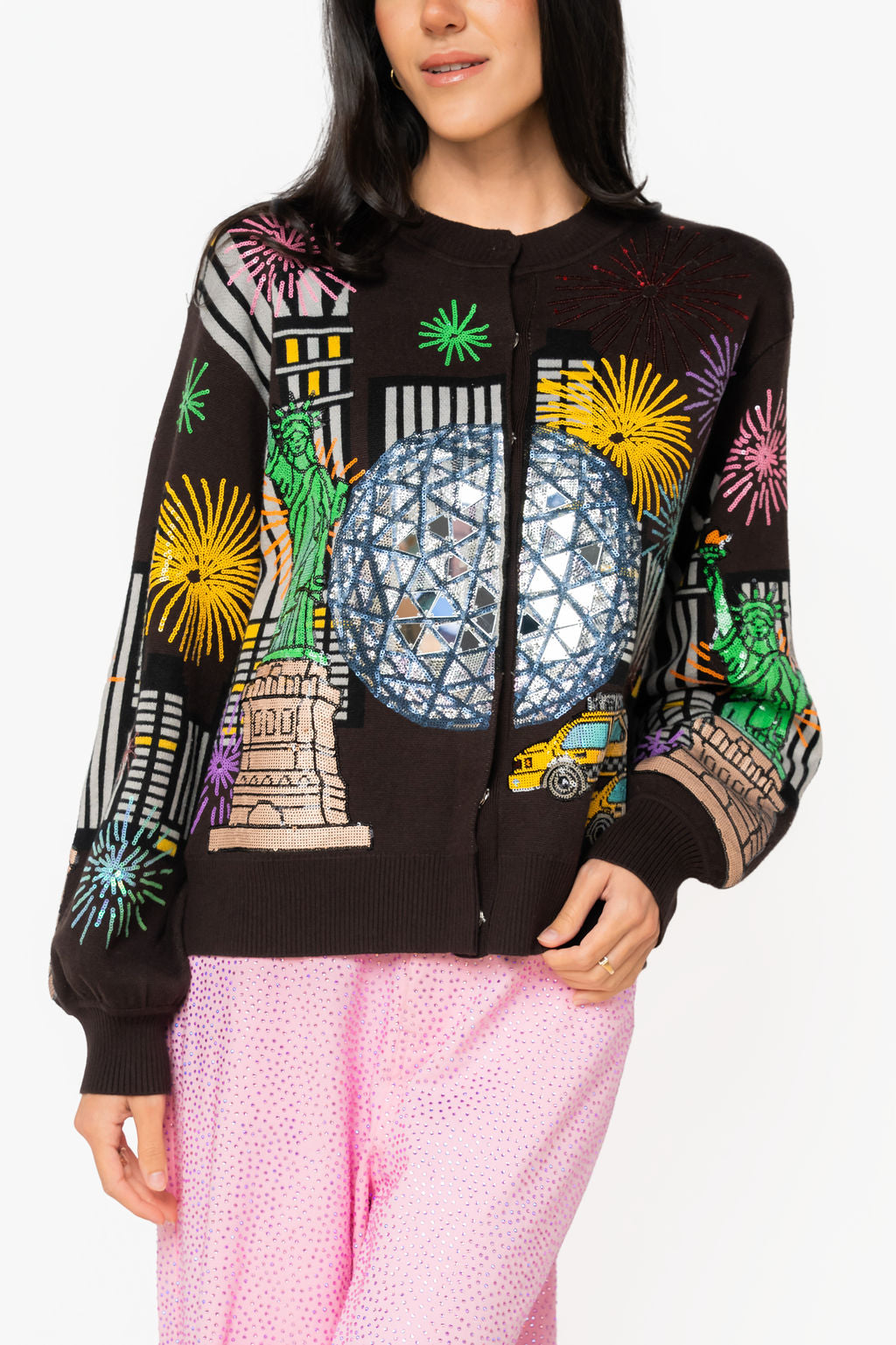 Front view of black Queen of Sparkles New Year's Eve cardigan with embellished New York City details, Statue of Liberty, yellow taxi, fireworks, and sparkling Times Square ball.