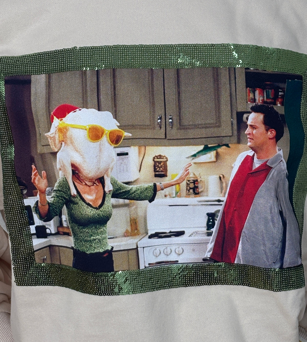 Close up of beige Queen of Sparkles Friends sweatshirt with Warner Bros.-licensed Monica turkey-head Thanksgiving artwork.