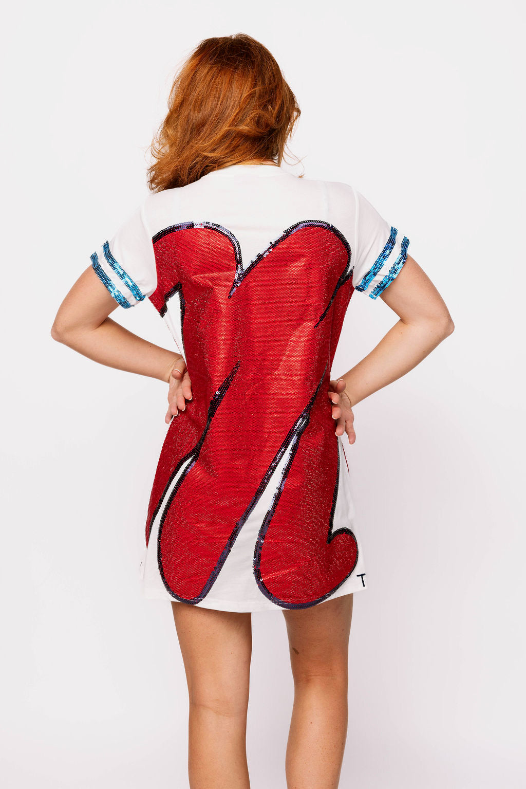 Model shown from behind wearing a white Queen of Sparkles tee dress with oversized red sequin Ole Miss lettering and navy and light-blue sleeve stripes.