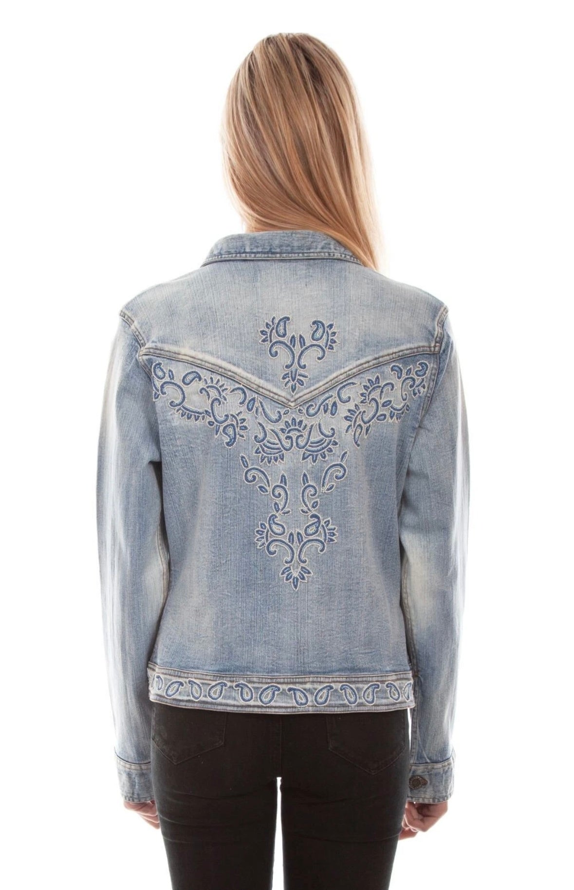 Back view of a model wearing the Scully light-wash denim jacket, showing the decorative scrollwork across its Western yoke and lower back.