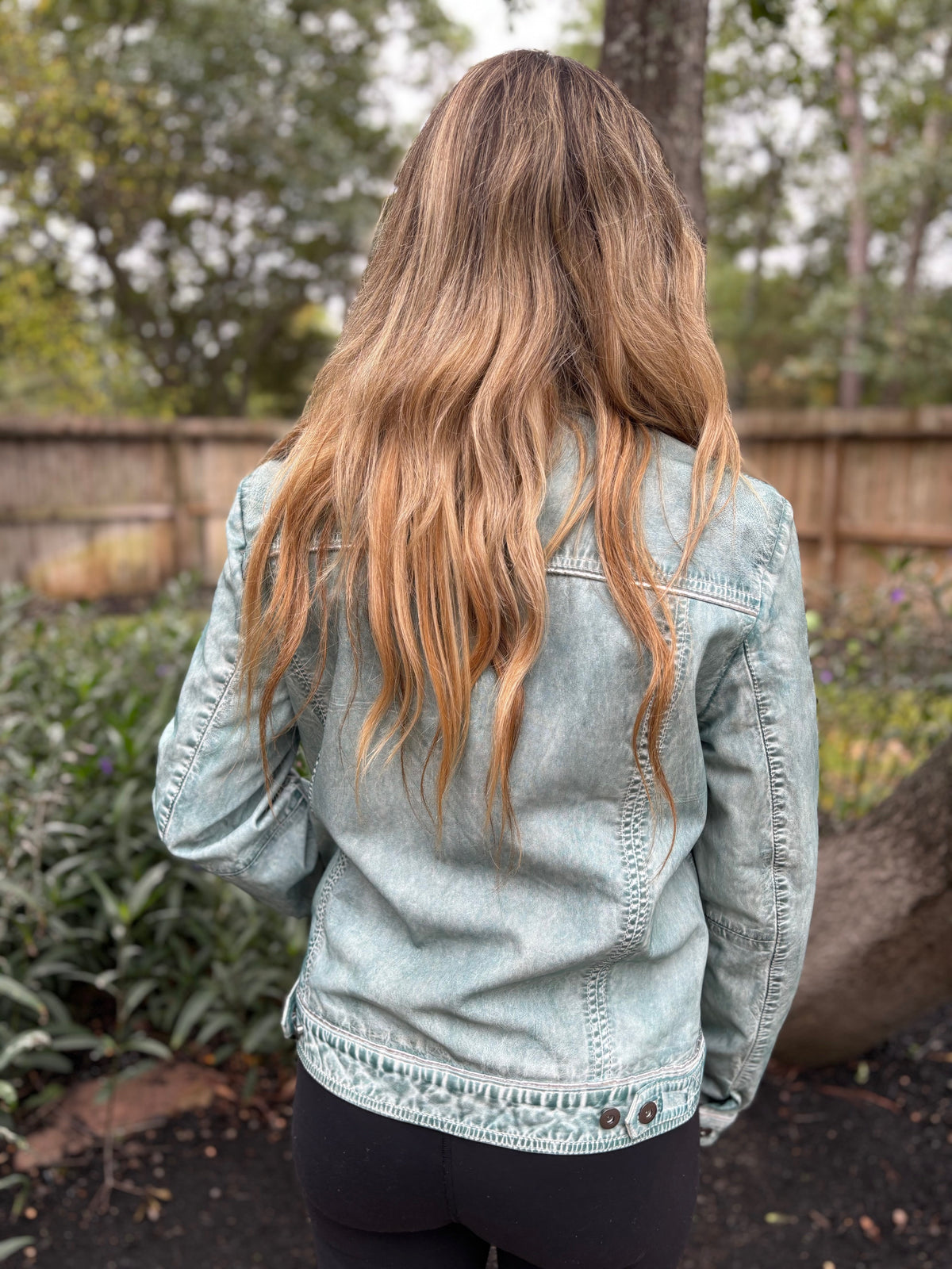 Back view of a model wearing the Scully pale-blue distressed leather jacket, showing the back seams and buttoned hem.